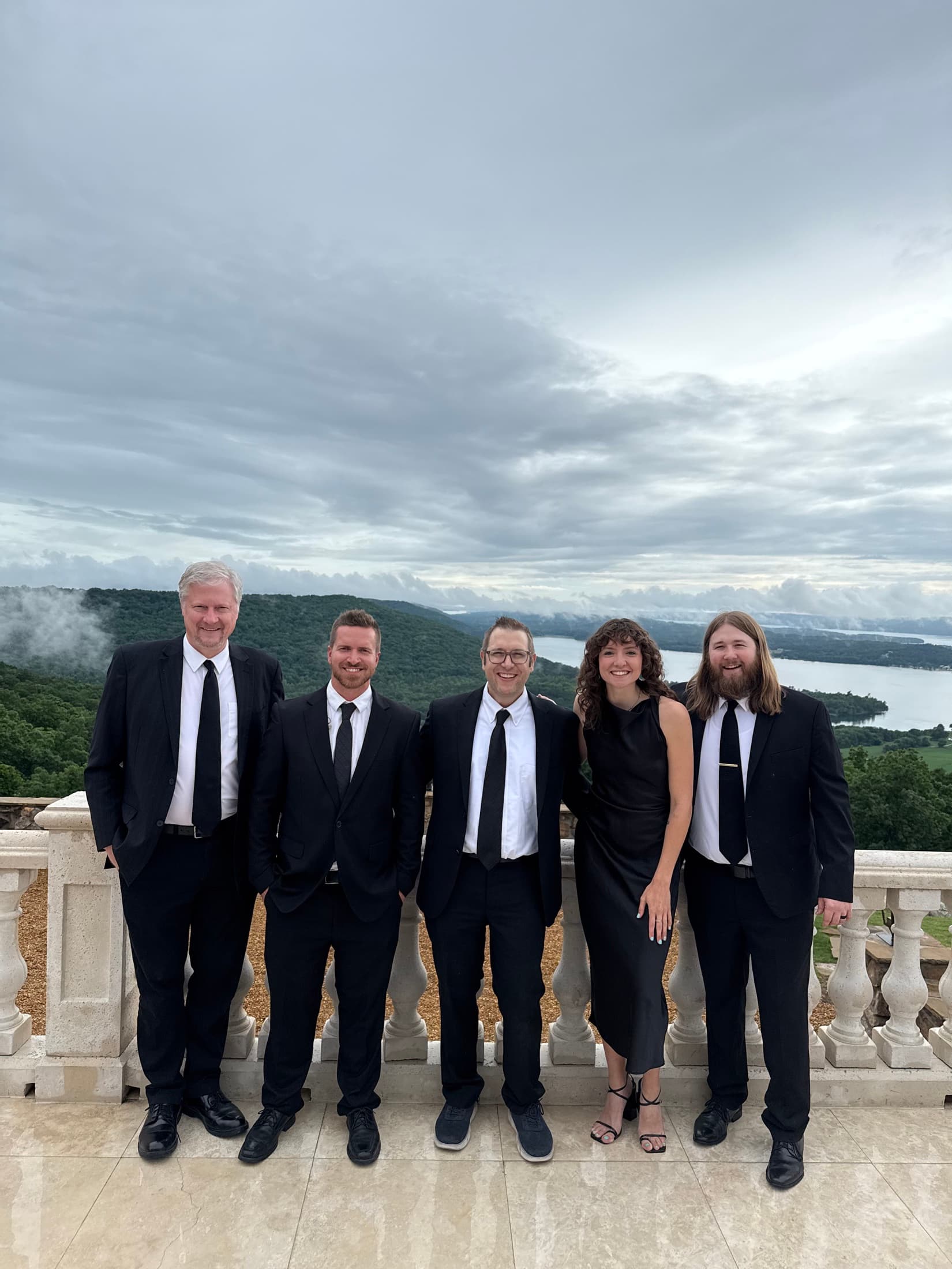 Party of 5 dressed for an event on a scenic balcony